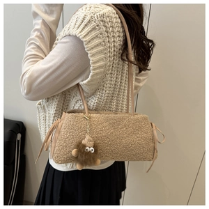 Detail of light camel faux shearling shoulder bag with plush monster charm and leather drawstring