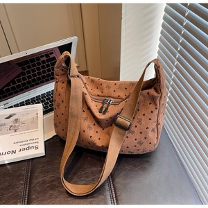 Close-up of brown corduroy crossbody bag with heart prints and adjustable shoulder strap