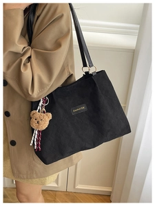 Détail du sac cabas matelassé noir avec étiquette Creative Cat et breloque ourson