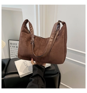 Detail of dark brown suede crescent bag with adjustable leather strap and metal buckle