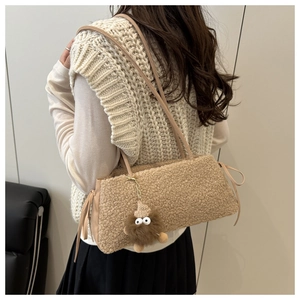 Fleece shoulder bag with monster pendant shown on model in cozy autumn winter style