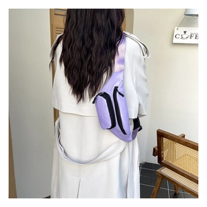 Close-up of purple waterproof nylon chest bag with adjustable strap and zip pockets