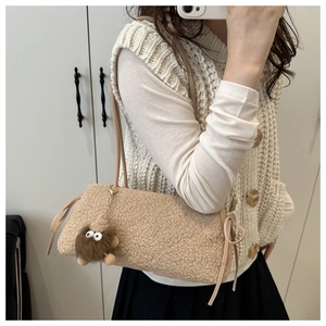Detail of soft sherpa hobo bag with delicate side ribbon bow and cute plush pendant