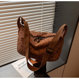 Detail of brown corduroy crossbody bag with heart prints and adjustable strap