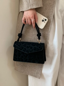 Fashionable black leopard print handbag with knotted handle and gold metal ring details