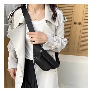 Side view of a waterproof black oxford cloth chest bag with adjustable strap on a model