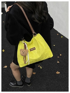 Vue détaillée du grand sac cabas matelassé jaune avec anses en cuir brun et petit ours