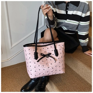 Détail du cabas plissé rose avec nœuds noirs porté par un mannequin en escalier