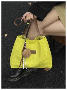Détail du cabas matelassé jaune avec poignées en cuir et étiquette Creative Cat