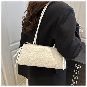 Detail of white faux shearling mini crossbody bag with drawstring on black blazer