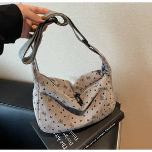 Detail of grey corduroy hobo bag with heart patterns and adjustable wide strap