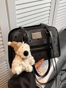 Black polka dot tote bag with woven texture and bear charm shown in hand