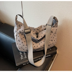 Detail of light gray corduroy hobo bag with heart bow prints and adjustable strap