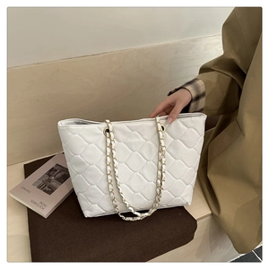 Close-up of a white quilted tote bag with gold chain strap for daily commute