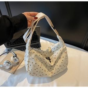 Detail of cream corduroy crossbody bag with brown heart and bow patterns and black zipper