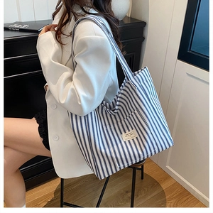 Detailed shot of large blue striped canvas tote bag with a minimalist woven label