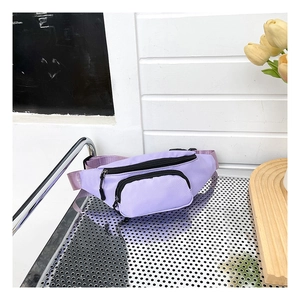 Detail of lavender oxford cloth waist bag with dual zippers on a silver metal table