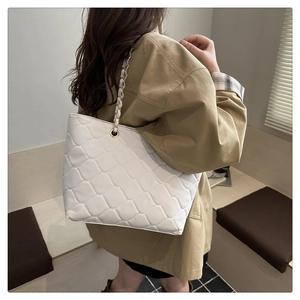 Detailed view of white quilted leather tote bag with elegant silver chain shoulder strap