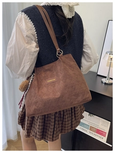 Détail du sac cabas matelassé marron foncé avec étiquette Creative Cat et pompon