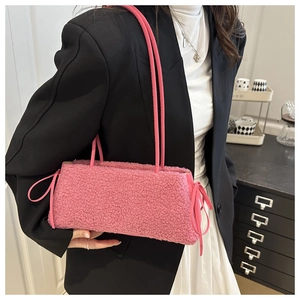 Detailed texture of pink plush lamb wool baguette bag with side bow ribbon decoration