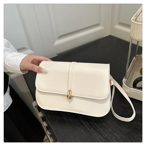 Detail of off-white baguette bag with gold metal clasp and smooth leather texture