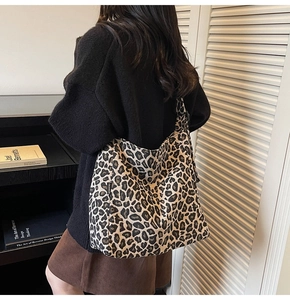 Detail view of large leopard print tote bag with FASHION label on canvas material