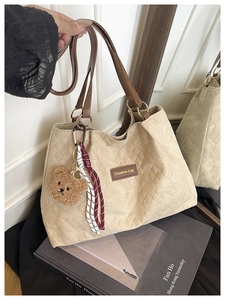 Détail du grand sac cabas matelassé beige avec breloque ours et étiquette en cuir