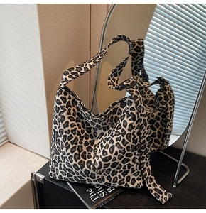 Close-up of leopard print canvas tote bag featuring a stitched fashion side label