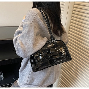 Side view of a black patent leather shoulder bag with bow details and rectangular shape