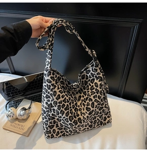 Detail of leopard print tote bag with FASHION label and adjustable strap in lifestyle setting