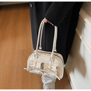 Close-up of white PU leather shoulder bag featuring bow details and front flap pockets