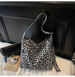 Detail of fashion tote bag with leopard print, wide straps and woven label