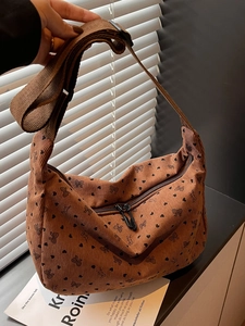 Brown corduroy hobo crossbody bag with heart and bow patterns and wide fabric strap