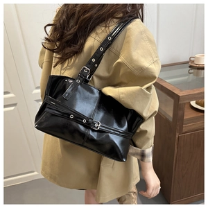 Dettaglio borsa tote in pelle verniciata nera lucida con fibbia in metallo argento