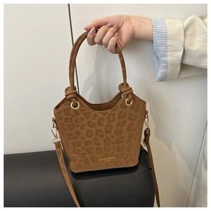 Detailed view of leopard print bucket bag with round handle and leather branding