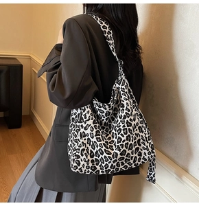 Detail of a large leopard print tote bag with a black fashion label on high-quality canvas
