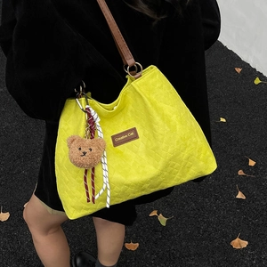 Sac fourre-tout en nylon matelassé jaune avec lanières en cuir et charme d'ours