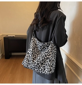 Detailed view of black and white leopard print tote bag with Fashion label and canvas texture