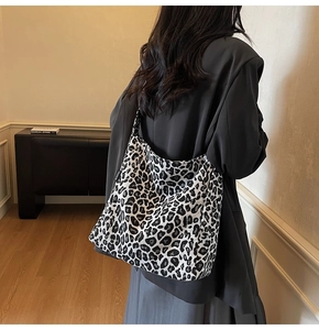Detail of leopard print tote bag with Fashion label paired with a grey suit jacket