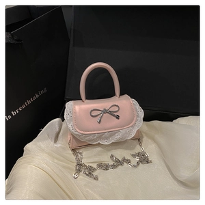Borsa rosa in ecopelle con fiocco argento e pizzo su sfondo di seta bianca