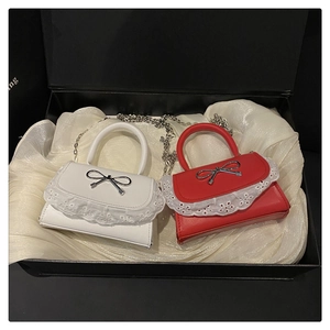 Dettaglio mini borsa con fibbia a fiocco argento e pizzo in confezione regalo di lusso