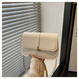 Close-up of cream rectangular baguette bag featuring smooth leather and gold metal clasp