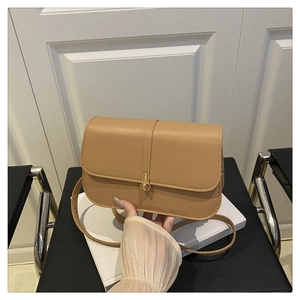Detail of khaki baguette bag featuring a gold round buckle and slim leather strap