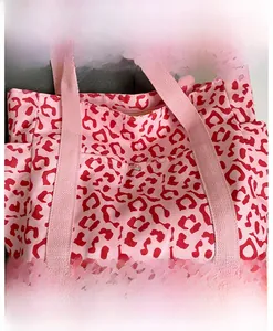 Detail view of pink leopard print tote bag featuring canvas texture and metal button snap
