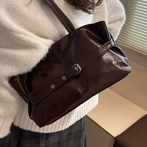 Elegante borsa tote in pelle verniciata cioccolato con fibbia indossata da modella