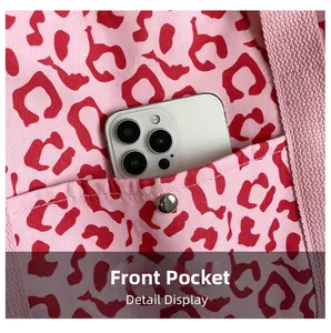 Detail view of pink leopard canvas tote with front pocket and metal snap button closure
