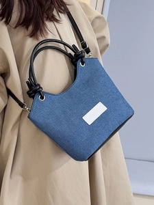 Sac seau en denim minimaliste avec poignée en cuir nouée et écusson logo blanc