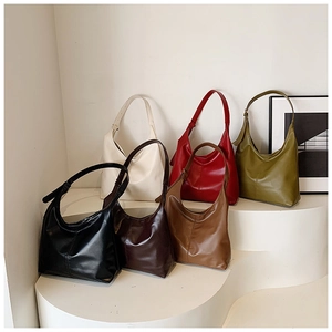 Multiple colors of minimalist large capacity hobo bags displayed on white pedestals
