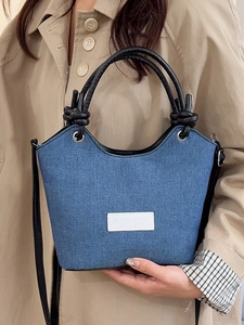 Sac seau chic en jean bleu foncé avec poignées en cuir noir et écusson logo blanc