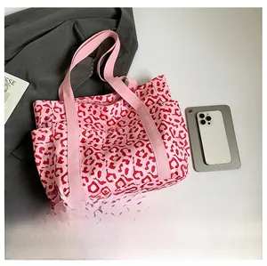 Detailed view of pink leopard print tote bag with side pockets and canvas strap handle